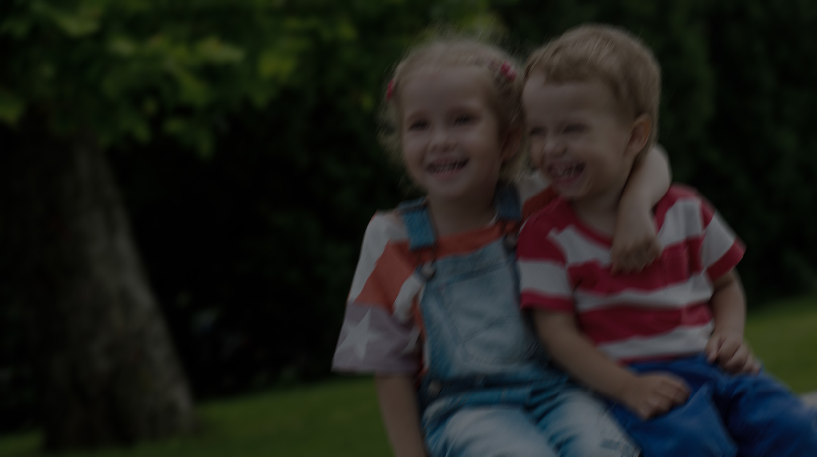 Happy Toddler brother and sister hugging in summer